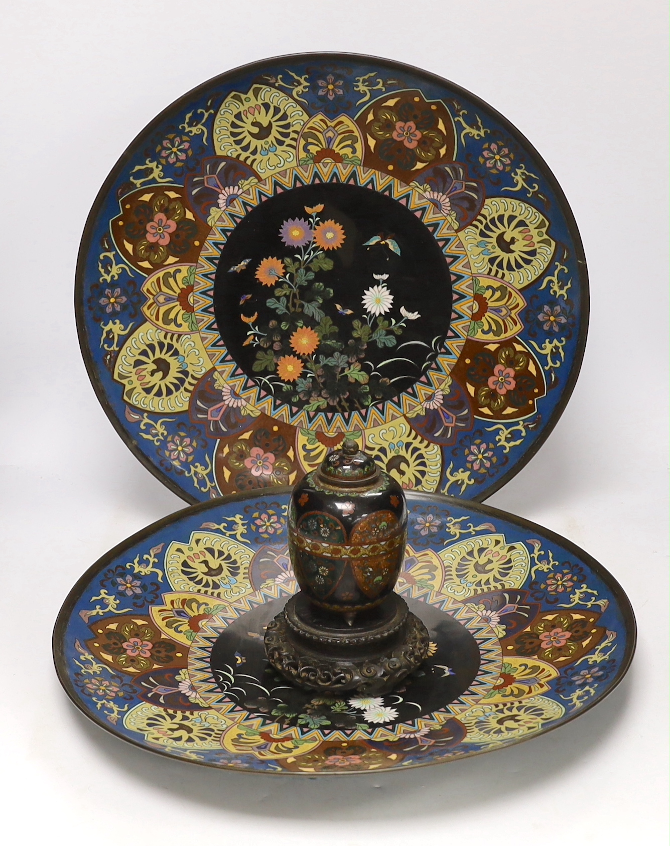 Two Japanese cloisonné enamel chargers and a finer cloisonne jar and cover on stand, largest 46cm (2)